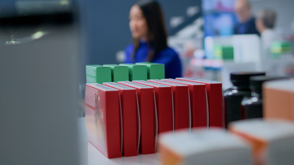 Customer buying medicaments in welcoming pharmacy shop, holding shopping basket. Portrait of happy client in drugstore looking for supplements and and medical pills